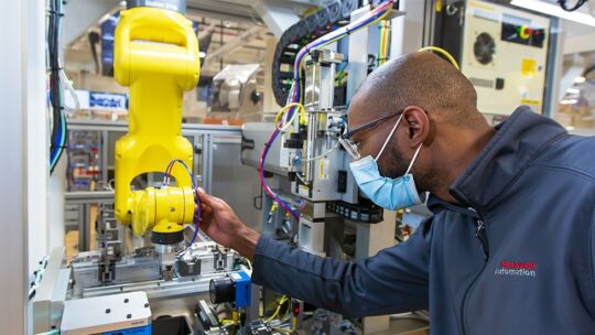 manufacturing professional uses industry 4.0 powered robotic arm