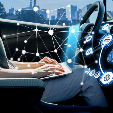Person, die während der Fahrt in einem autonomen Fahrzeug ein persönliches elektronisches Gerät verwendet