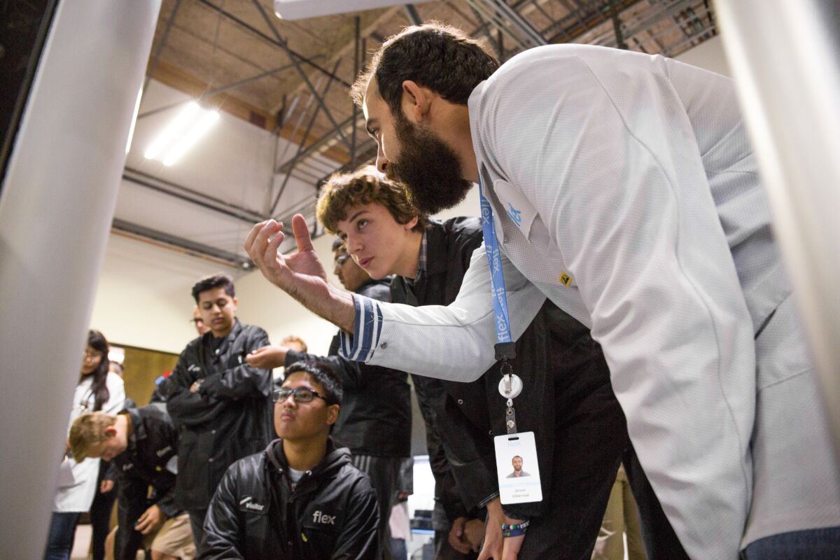 Flex employee teaching young manufacturing professionals