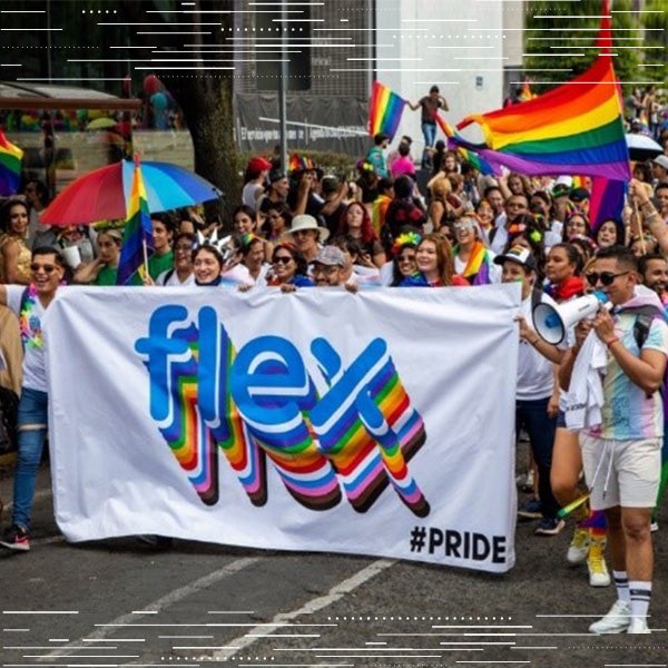 Flex employees gather outside to celebrate LGBTQ inclusivity with a rainbow colored flex banner