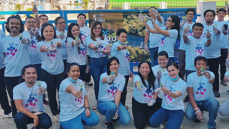 Flex-Mitarbeiter in Cebu, Philippinen, versammeln sich mit Blumen