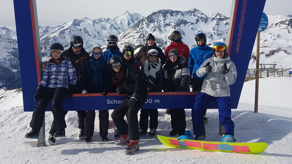 Group of apprentices on a snowboarding and skiing excursion in the mountains