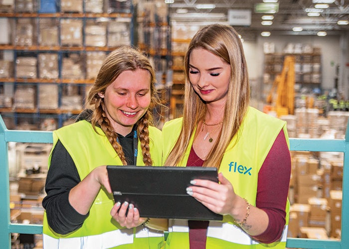 Two female Flex employees using a tablet to plan logistics