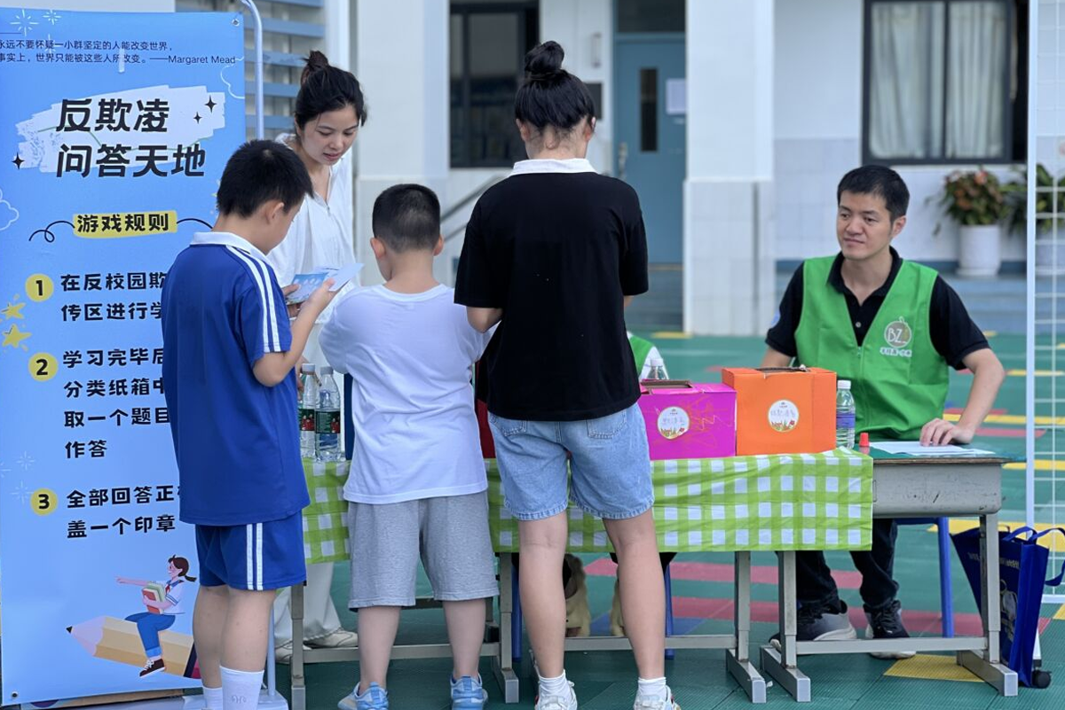 adults and children interact at a give2asia event