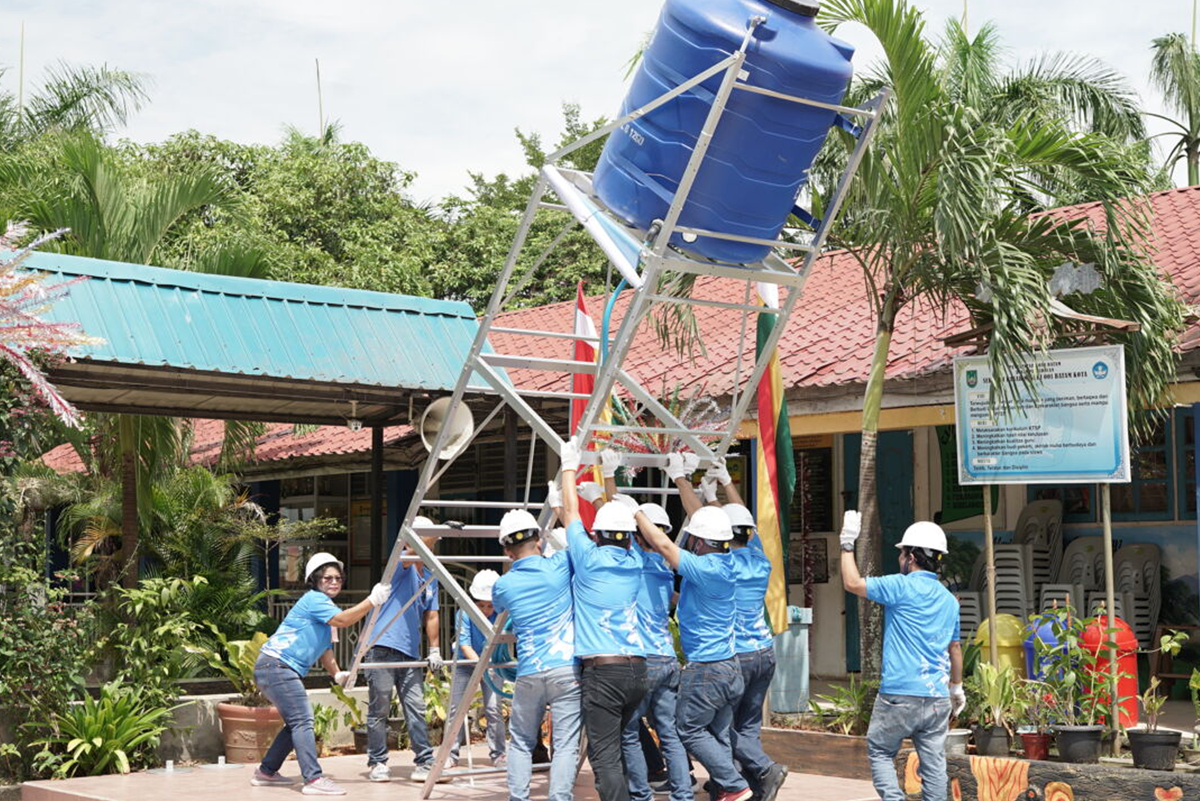 Empleados de Flex levantan una torre de agua en México