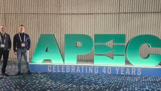 Flex Power Modules team members standing next to APEC sign at APEC 2025