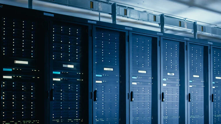 Row of illuminated server racks inside a data center.