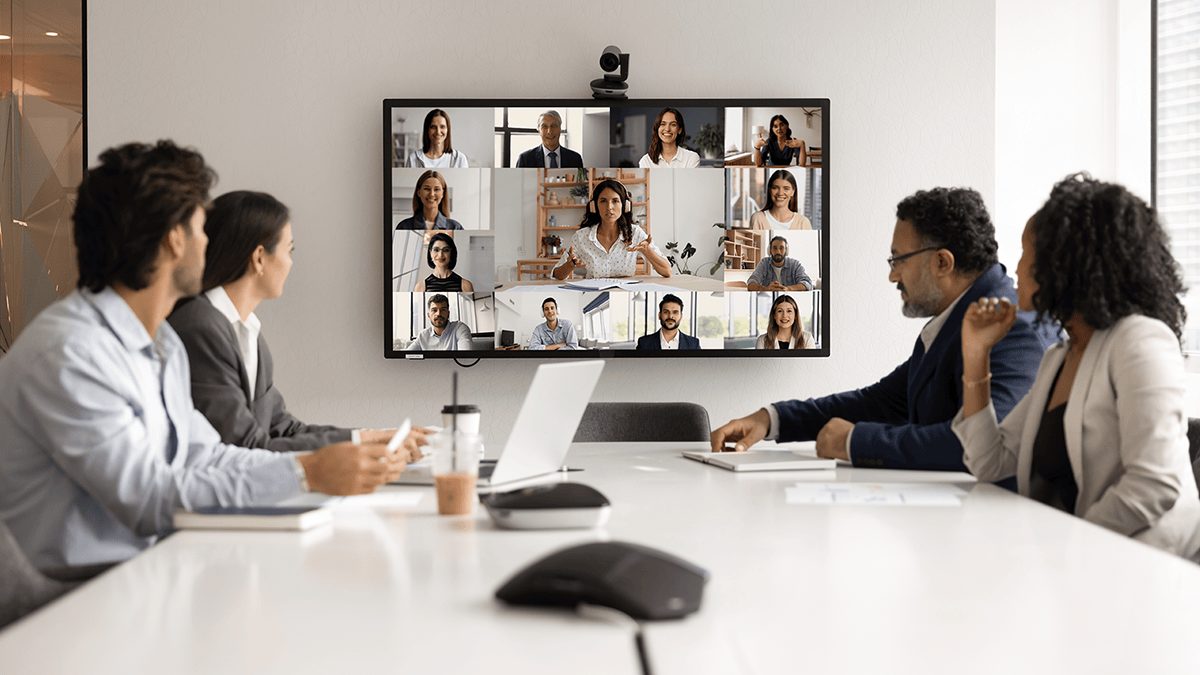 Group of people in an office conference room using AV conferencing systems